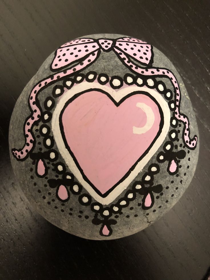 a painted rock with a pink heart on it