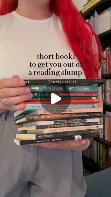 a woman holding a stack of books in front of a book shelf with the words short books to get you out of reading slump