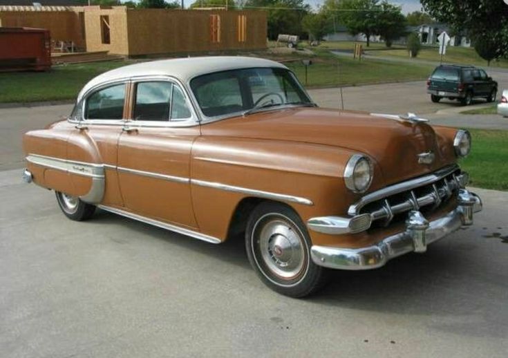 an old car is parked in a driveway