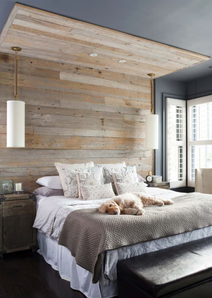 a bedroom with wood paneled walls and a bed in the middle, along with a bench