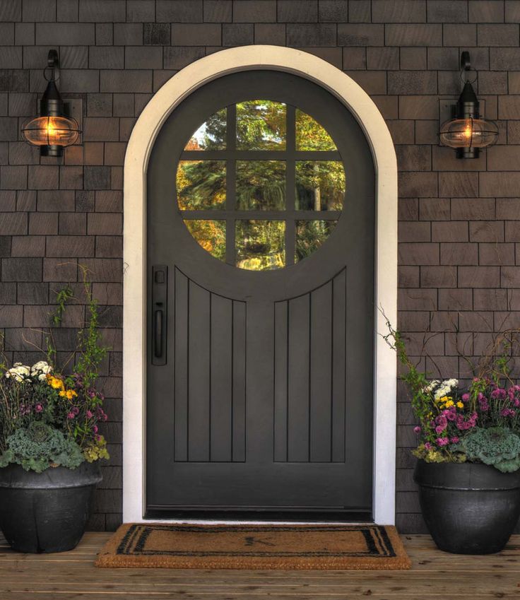 a gray front door with potted plants on the side and an open sign that says land's end development