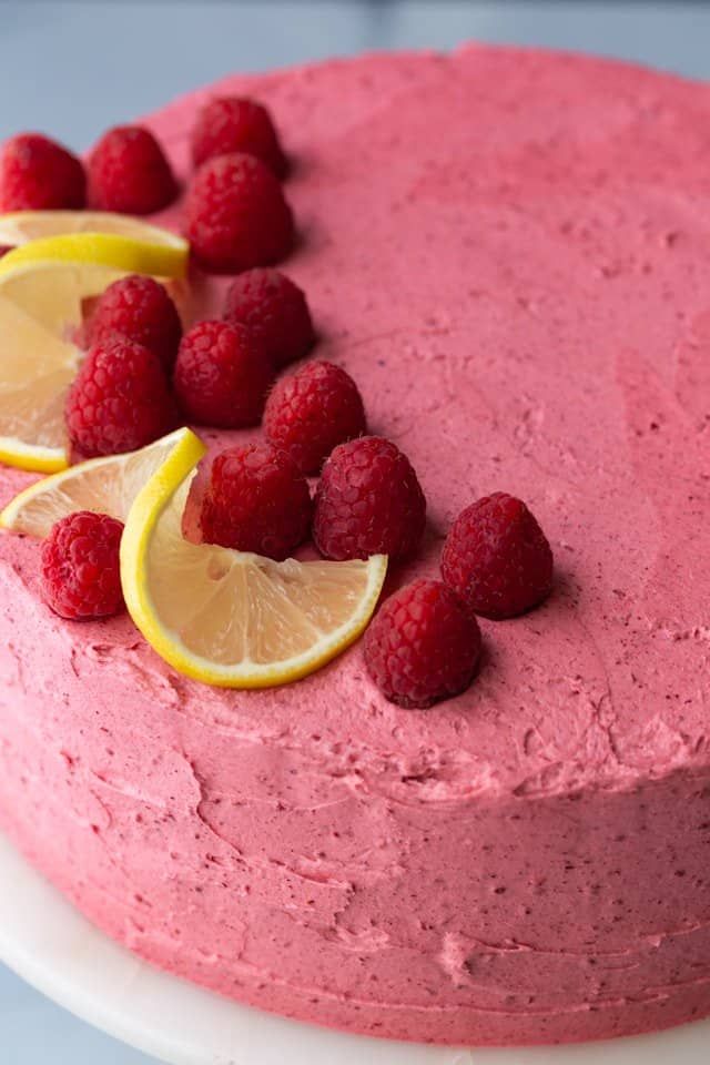 a cake with raspberry frosting and lemon slices