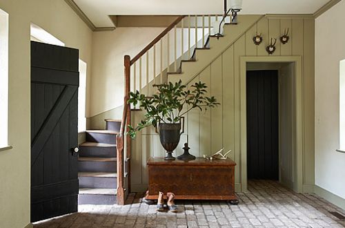 an entryway with stairs and potted plant on the floor in front of it