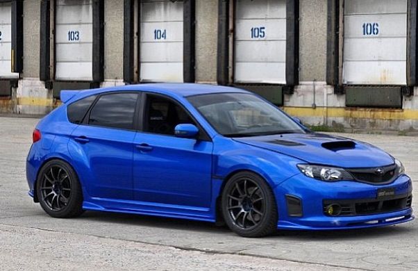 a blue car parked in front of a building