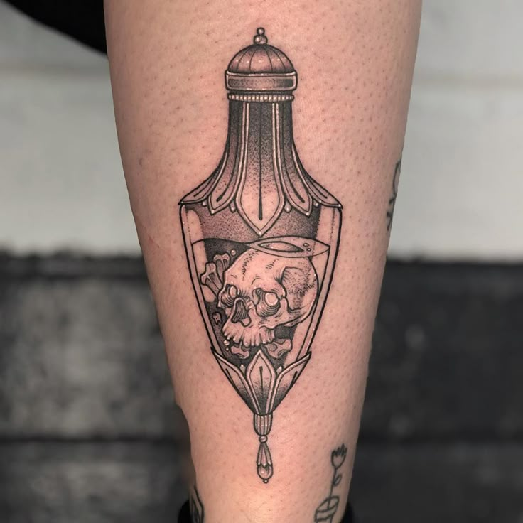 a tattoo on the leg of a person with a skull in a light bulb design