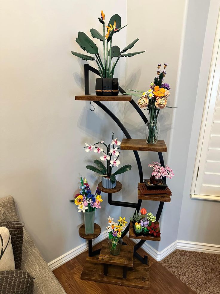 three wooden shelves with flowers and plants on them