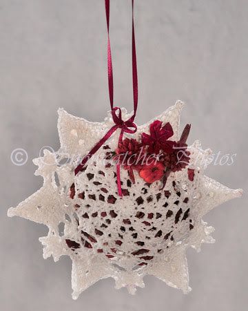 a white ornament hanging from a red ribbon