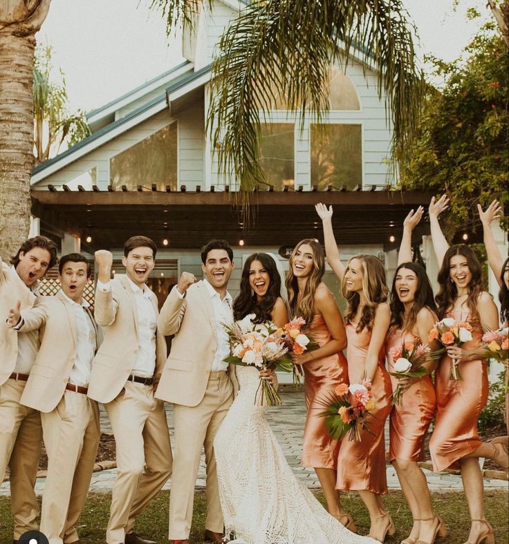 a group of people standing next to each other in front of a house with palm trees