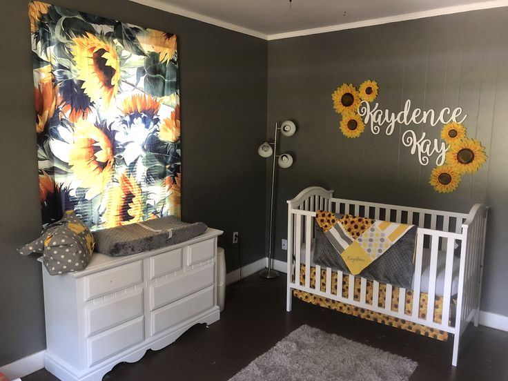 a baby's room with sunflowers painted on the wall and crib