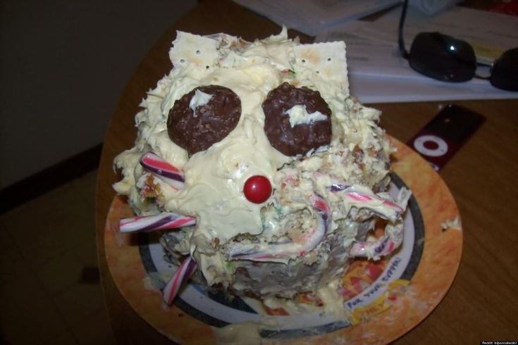 a close up of a cake with icing and candy canes in the shape of a cat