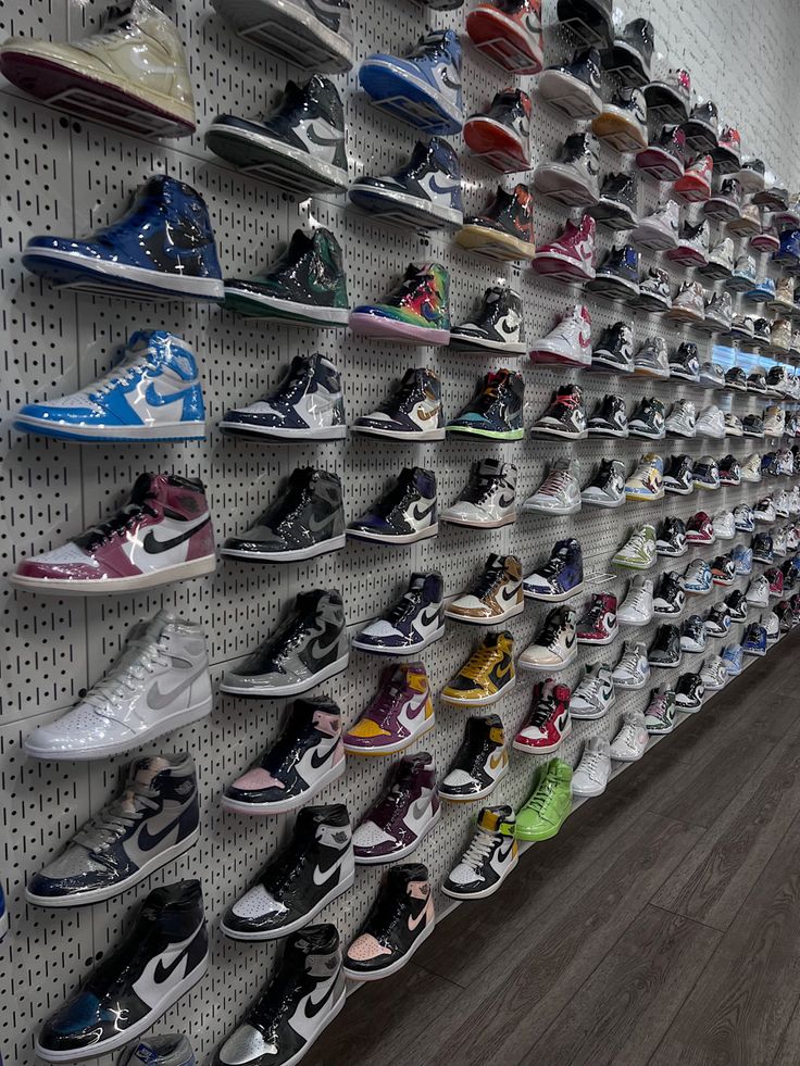 there are many pairs of shoes on the wall in this store that is full of them