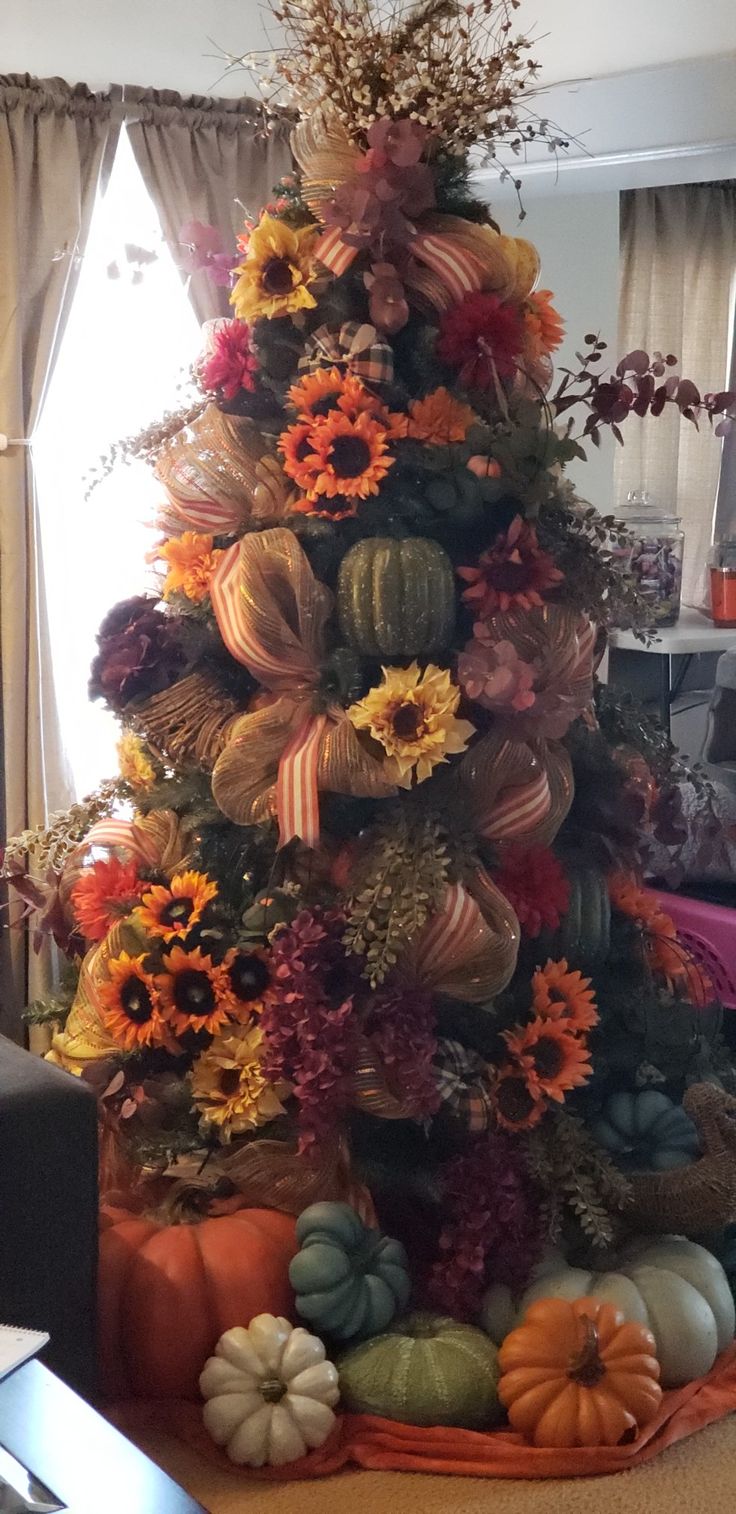 a decorated christmas tree with pumpkins and sunflowers