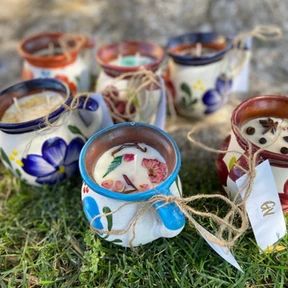 several small cups with flowers painted on them sitting in the grass next to each other