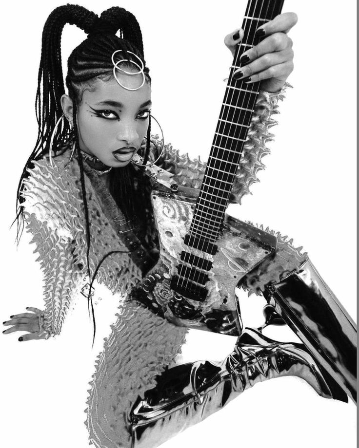 a woman with dreadlocks holding a guitar