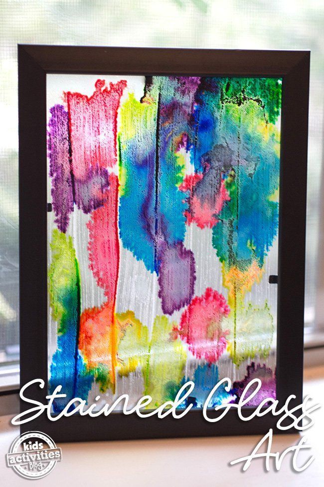 an art project with watercolor paint and black frame on a window sill in front of