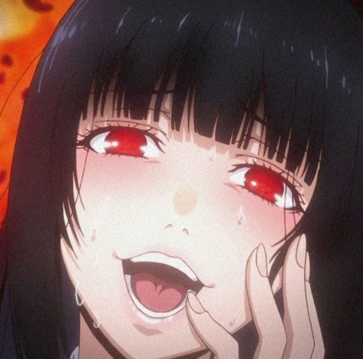 a woman with red eyes and black hair holding her hand up to her face while looking at the camera