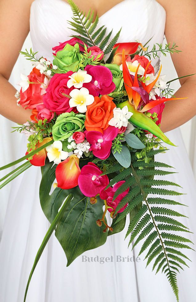 a bride holding a bouquet of flowers and greenery