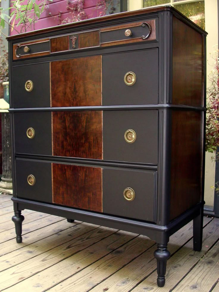 an old dresser is painted black and brown