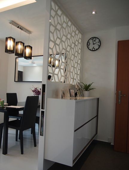 a dining room table with black chairs and a clock on the wall behind it,