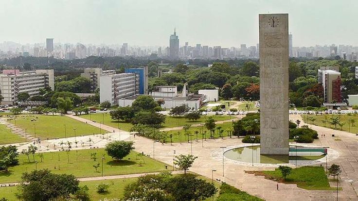 an aerial view of a city with tall buildings and green grass in the foreground