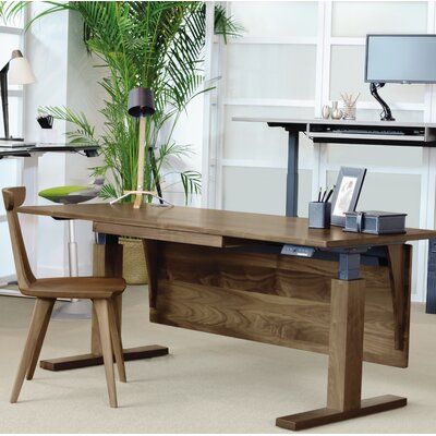 a wooden desk sitting in front of a computer monitor