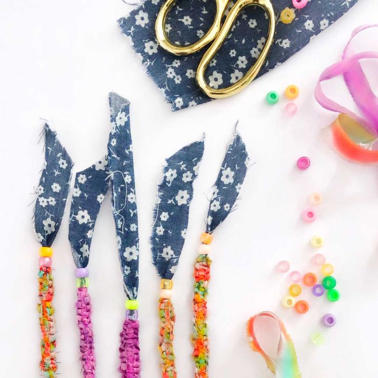 scissors, beads and other crafting supplies laid out on a white surface with confetti sprinkles