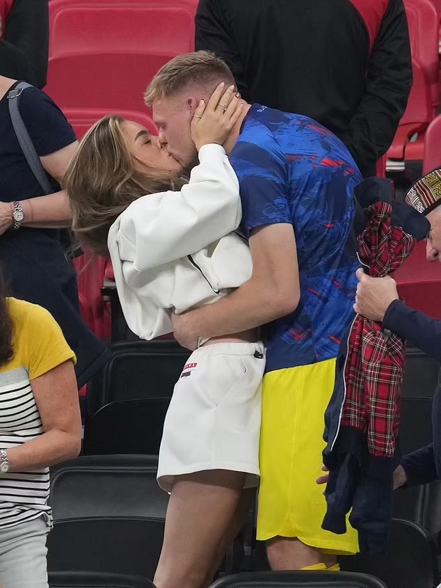 a man and woman kissing in the stands