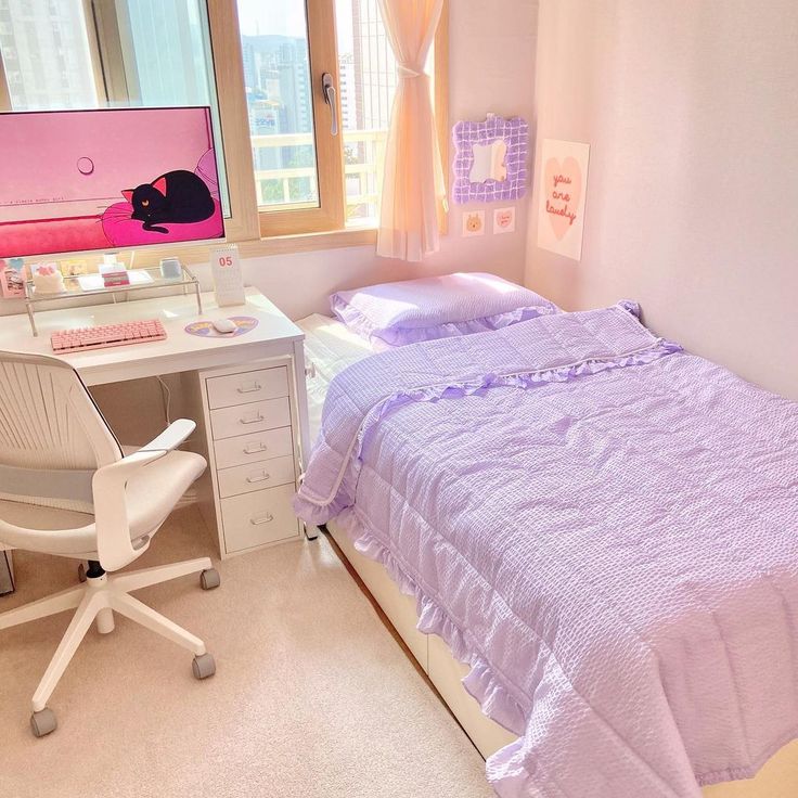 a bed room with a neatly made bed and a computer monitor on the desk next to it