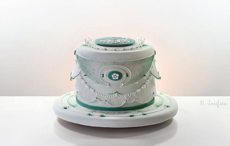 a white and green cake sitting on top of a table