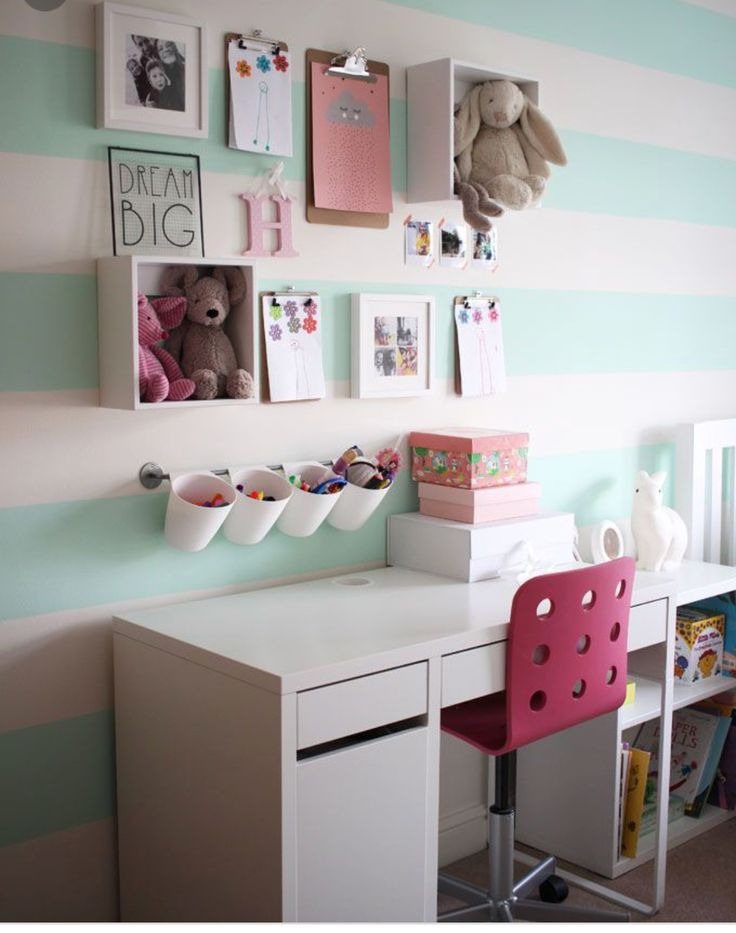 there is a desk and chair in this child's room with striped wallpaper