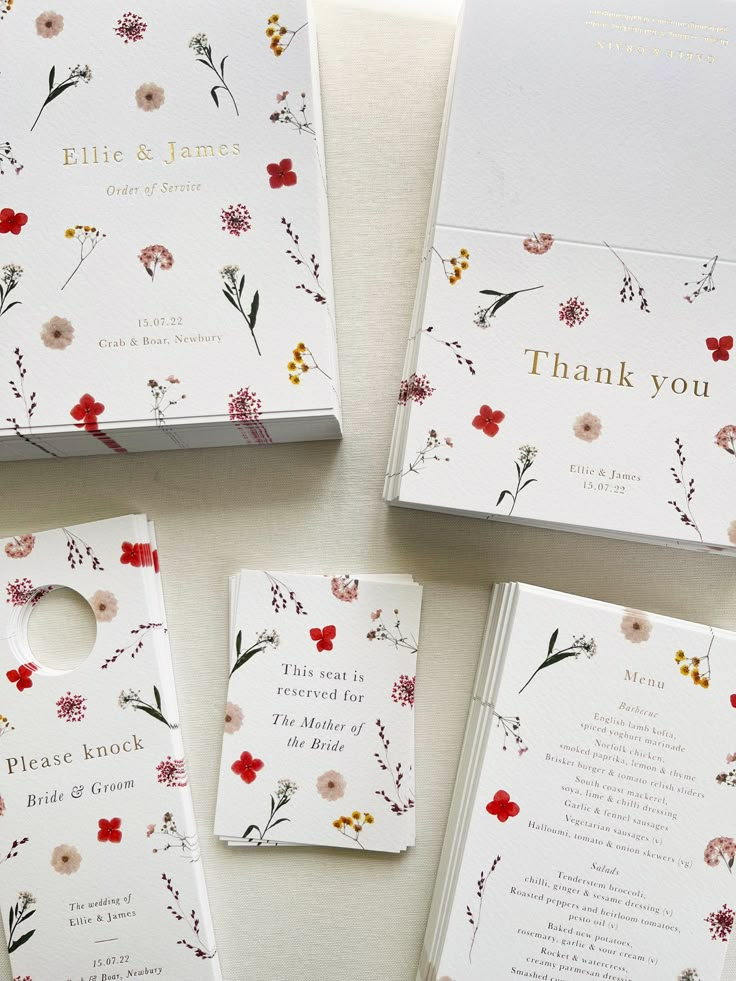 four wedding stationery cards with flowers on them