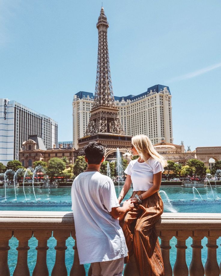 a man and woman looking at the eiffel tower