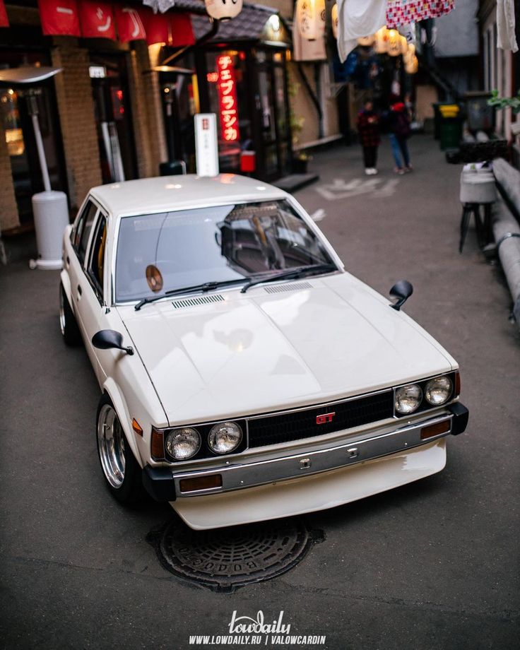 a white car is parked on the street