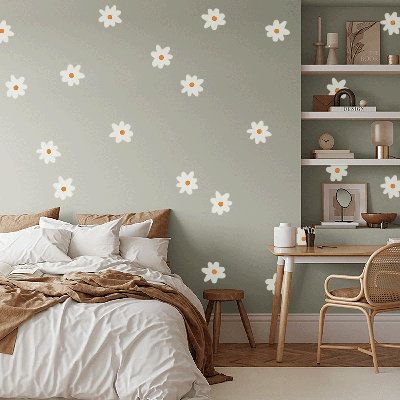 a bedroom with white flowers painted on the wall and a bed in front of it