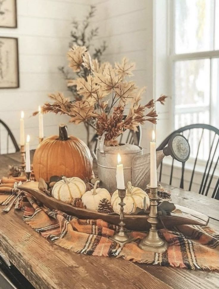 a wooden table topped with pumpkins and candles