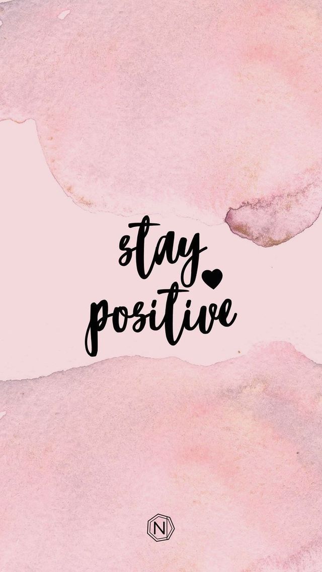 the words stay positive written in black ink on a pink watercolor painted paper background