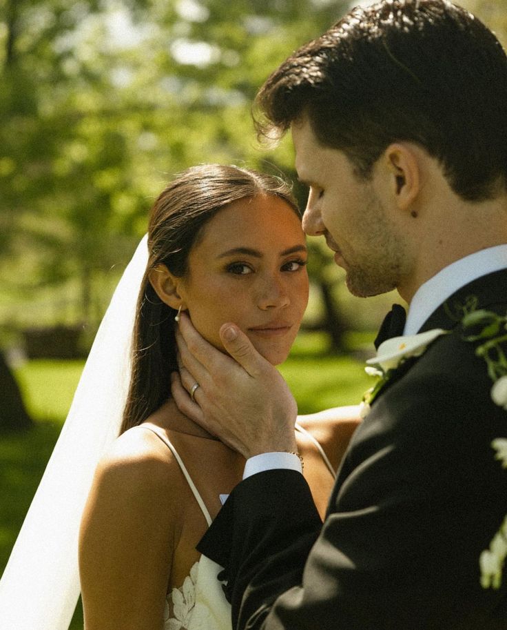 a bride and groom are posing for a photo in their wedding day at the park