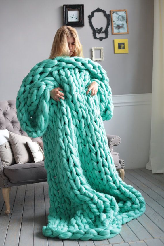 a woman wrapped in a large chunky blanket