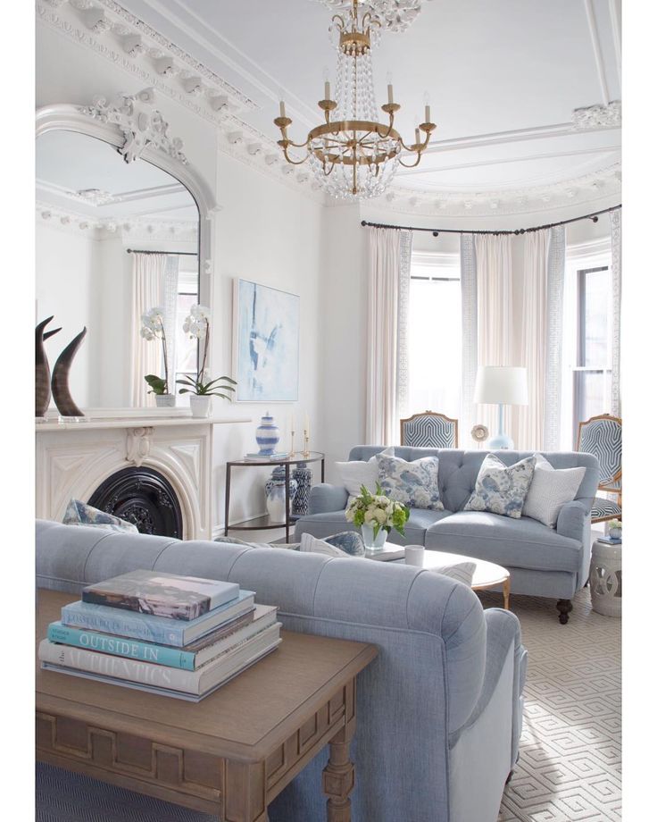 a living room filled with furniture and a fire place in front of a mirror on the wall