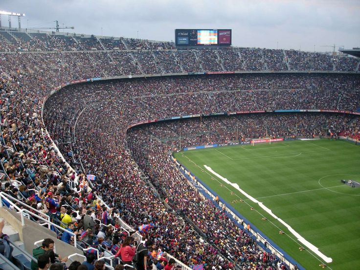 a large stadium filled with lots of people sitting on the bleachers watching a soccer game