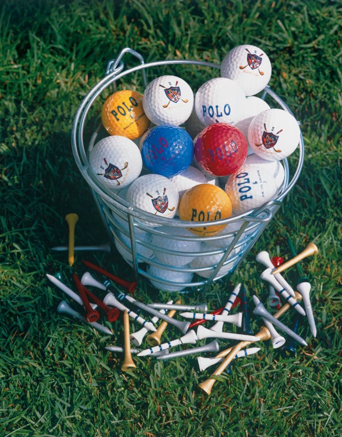 a basket full of golf balls and tees on the grass