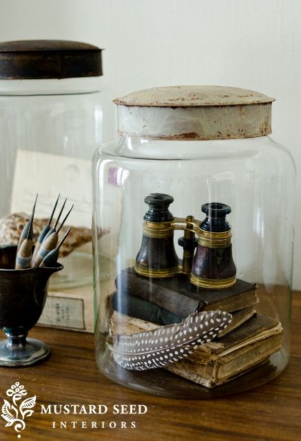 two glass jars filled with items on top of a wooden table