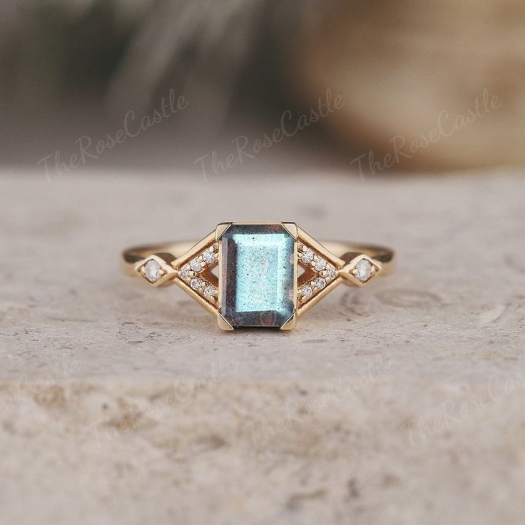 a gold ring with an aqua blue stone and diamonds