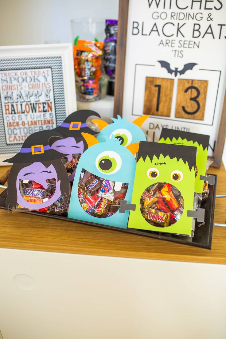 halloween treat bags in the shape of monster faces on a table with other items behind them