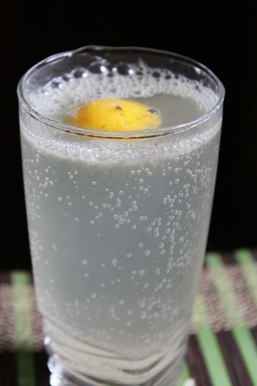 a glass filled with liquid and a lemon