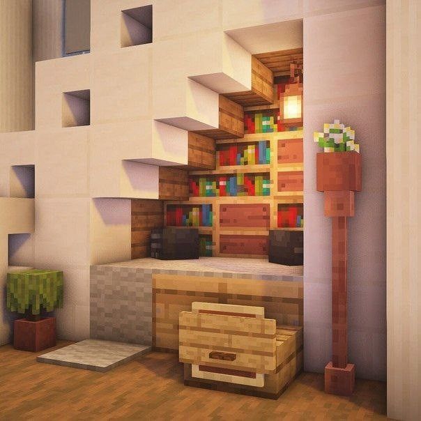 a living room filled with lots of furniture and bookshelves next to a stair case