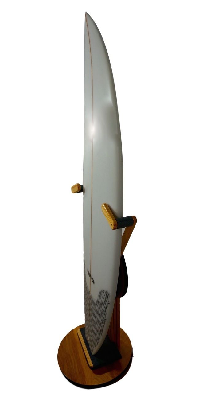 a white surfboard is standing on a wooden stand