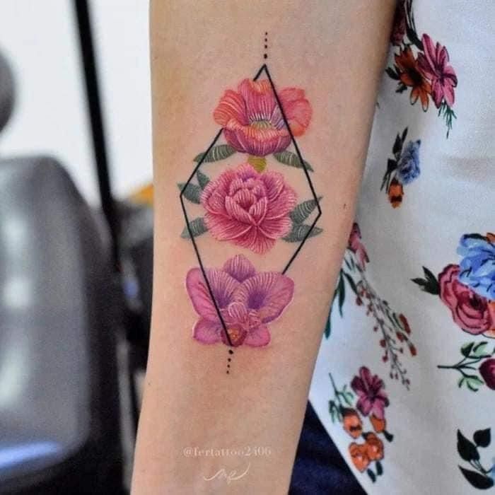 a close up of a person's arm with a flower tattoo design on it