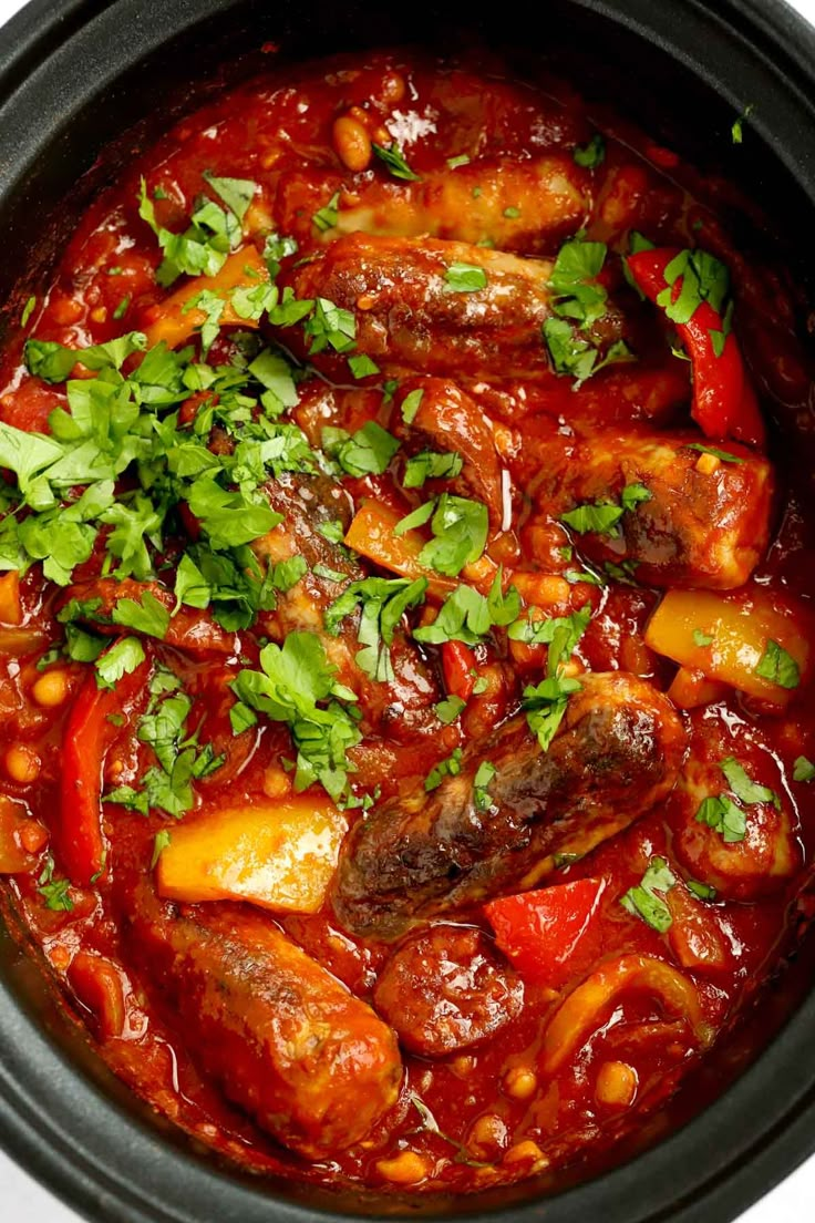 a close up of a stew in a crock pot with garnishes