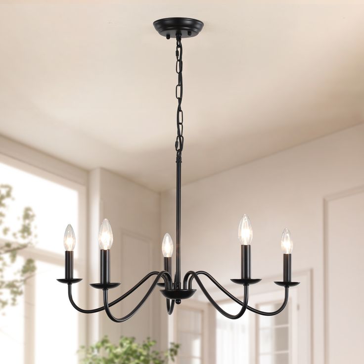 a black chandelier with five lights hanging from it's centerpiece in a room